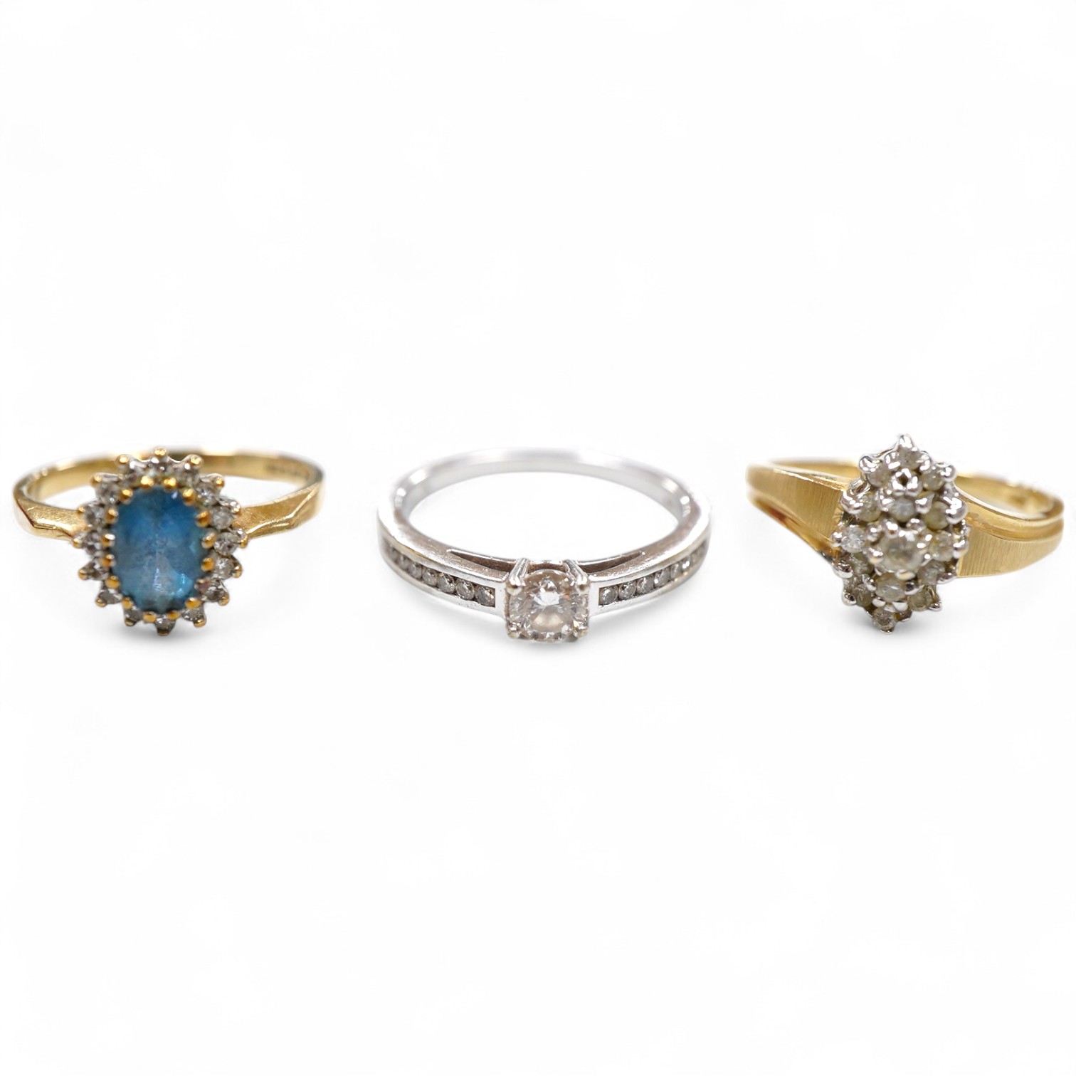 A collection of three rings, comprising: a ring, set with a brilliant-cut diamond weighing approximately 0.20 carats, to shoulders set with smaller brilliant-cut diamonds totalling approximately 0.16 carats, mounted in 9